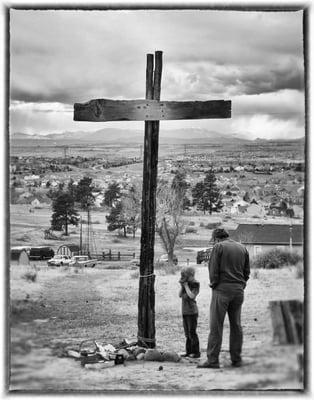 Reflecting at the cross behind the church.