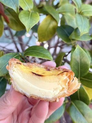 Portuguese Egg Tart in half to shore the custard amount.