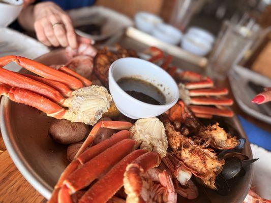 Another photo of a bowl of butter, crab, lobster, shrimp, corn, and potato.