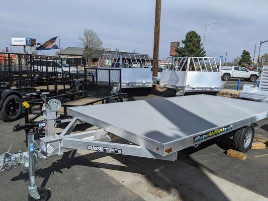 12' Raft Trailer from Aluma Ltd with winch tower on front and full-width roller on rear. Features Nudo polyethylene decking for longevity