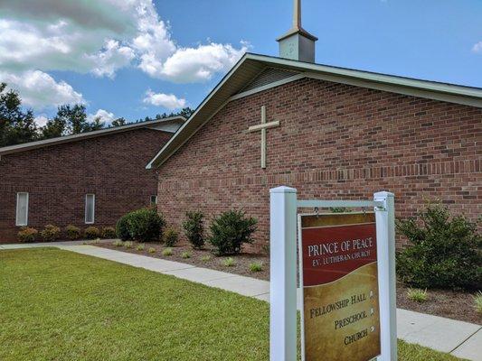 Front of building with directional sign.