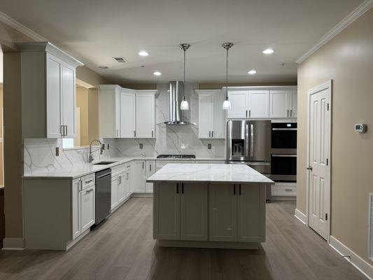 Modern kitchen with white shaker cabinets, gorgeous quartz countertops and full height quartz backsplash