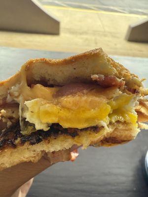 Pandesal breakfast sandwich. Crispy bacon, gooey fried egg and melted cheese.