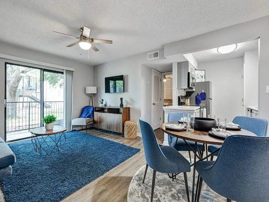 A living room and dining room with a sliding glass door