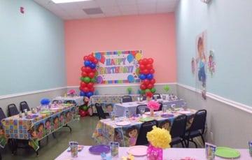 Party Room where the Kids sit to eat. Table decor (except for the tissue paper flowers) and balloons provided by venue.