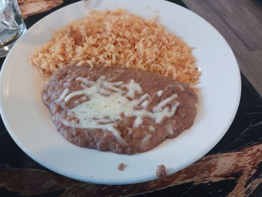 Rice and refried beans that come with tacos paisa