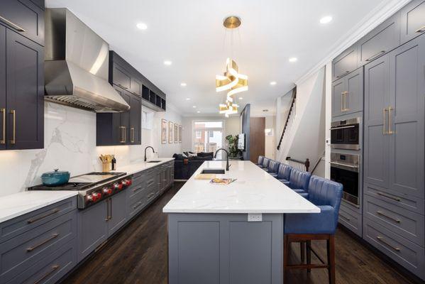 Central to the kitchen's allure is a striking aged brass chandelier, suspended with precision above the island.
