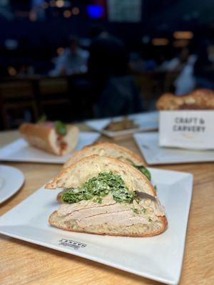 Turkey-Kale Caesa featuring rotisserie turkey breast, kale caesar dressing, & parmesan on a ciabatta roll.