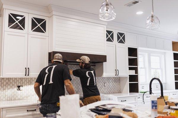 Adding trim to hood vent in kitchen.