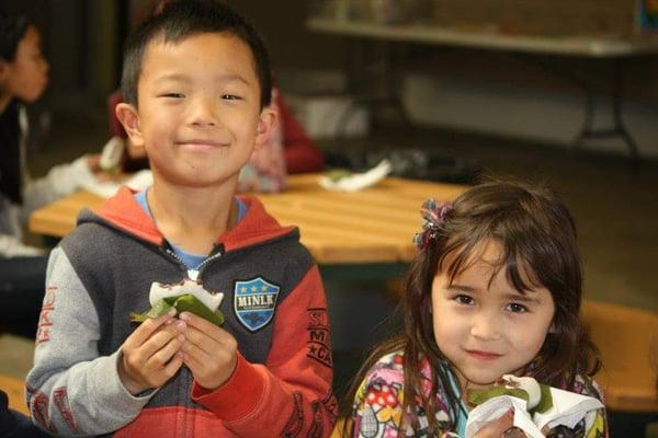 Students enjoy traditional snacks at Children's Day event