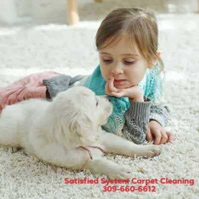 Little girl and puppy laying on fresh cleaned carpet cleaned by Satisfied System.