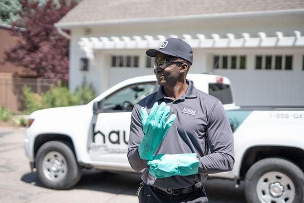 Hawx technician gearing up for residential service--gloves, eyewear, and truck ready to treat ants, spiders, and other pests.