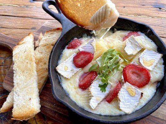 Indulge in the perfect blend of creamy Baked Brie, local honey and fresh strawberries with toasted sourdough! Great with glass of wine.