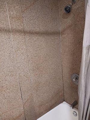 Cracked up and outdated bathtub walls.