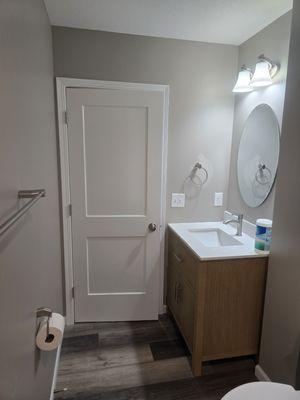 Basement bathroom renovation including painting, trim work, floor installation, vanity and accessories