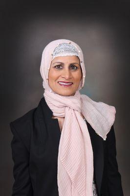 A professional woman with a warm and approachable demeanor. She has expressive eyes and a confident smile that enhance her natural features.