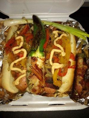 Bacon Wrapped Dog topped with carmalized onions and bell peppers & Chipotle Sauce.  With a grilled jalapeno and green onion on the side