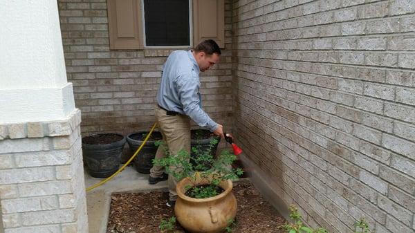 Tyson is treating the outside of a house with his power sprayer.