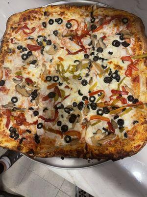 Sicilian pizza with olives, peppers , banana peppers topped with fresh mozzarella cheese