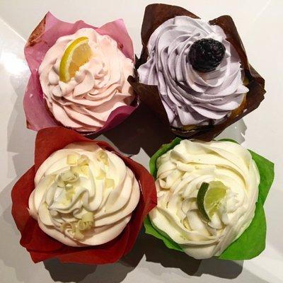 Pink lemonade cupcake, lemon cupcake with lavender icing, red velvet cupcake with cream cheese icing, and key lime cupcake