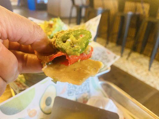 First bite of loaded nachos with carne