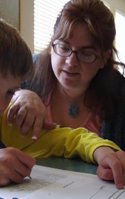 Michelle Thomas, owner, works with a student in his home.