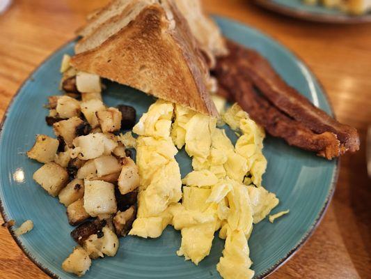 Bacon scrambled eggs and toast with home fries