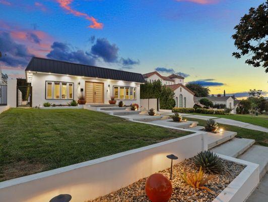 Gorgeous walls with a Natural Grass and steps to the front door. the lighting is amazing, plants are all low maintenance.