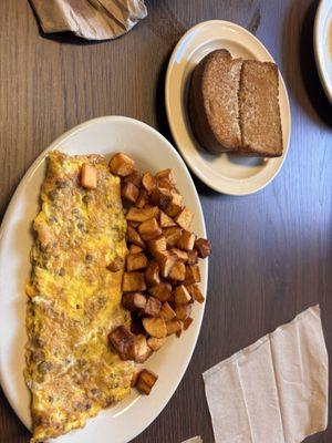 Senior size order Sausage and cheese omelette with fried potatoes.