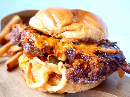 The Fustercluck! A Tandoori fried chicken sandwich with gochujang aioli, achara, halal bacon, BP sauce & pepper-Jack cheese on a brioche bun