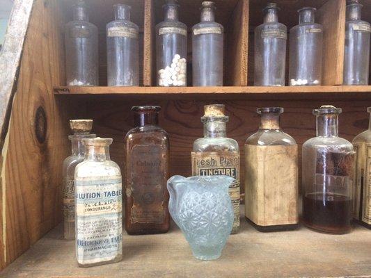 Various antique medicines line the shelves.