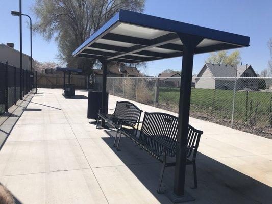 Shaded seating next to tennis courts