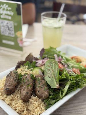Lamb kofta combination plate with white rice, house salad, hummus, and pita on the side. Yummy mint lemonade in the background.