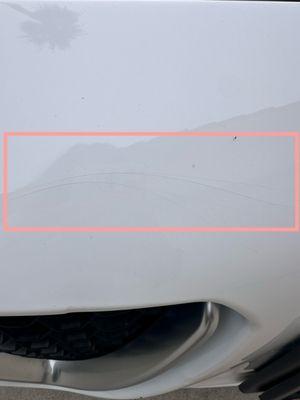 The paint has cracked under pressure. The bumper flexed during the impact, causing the paint layer to break
