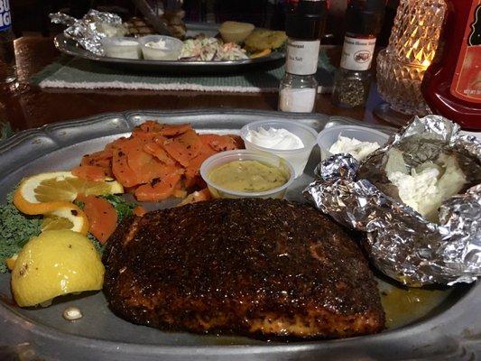 Blackened salmon with carrots and a baked potato.