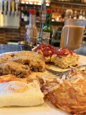Chicken fried steak and eggs with hash browns and a freshly made biscuit with butter and raspberry jam