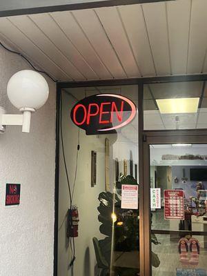 Showing the open sign is on after she stated it was too late to tan at 7:49 when it was 7:44