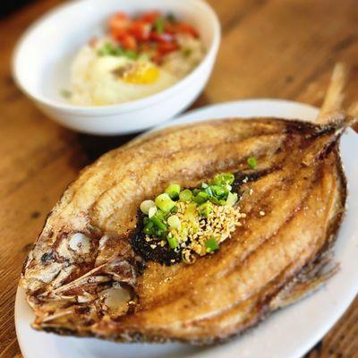 Bang-Silog served with garlic rice, tomato salad, and fried eggs.