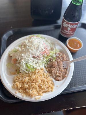Potato flautas with everything on top, rice, beans, a side of salsa, & a bottle of sangria.