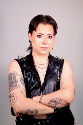Portrait of a queer person in a biker vest