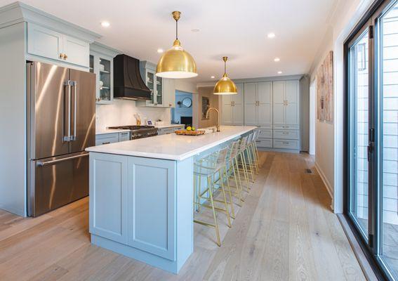 Elegant kitchen design with a grand island, soft blue cabinets, and stylish gold accents. Perfect for entertaining.