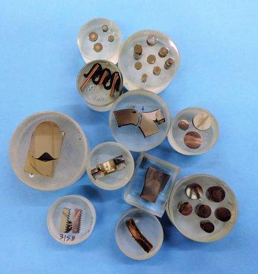 Metal test samples mounted in epoxy, ready for examination.