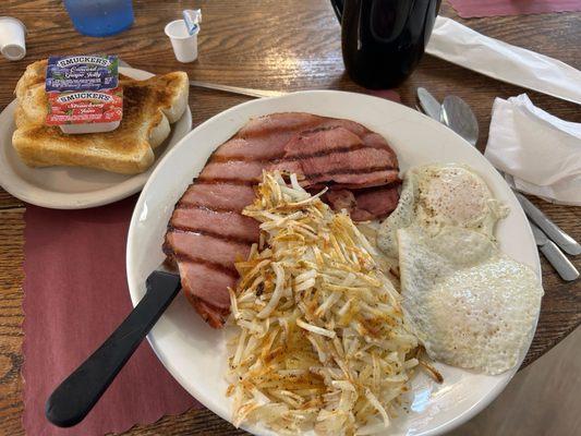 Ham eggs and hash browns and homemade bread for breakfast