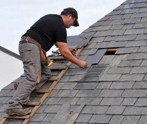 Roofing specialist installing shingles
