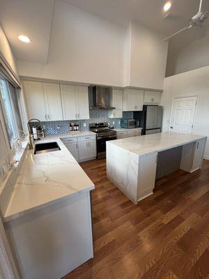 New kitchen remodel White shaker cabinets, quartz waterfall island, stainless appliances & a modern backsplash.