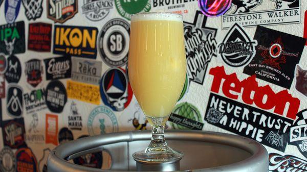 One of our haziest hazies, Opaque, in front of our sticker wall at the brewery.