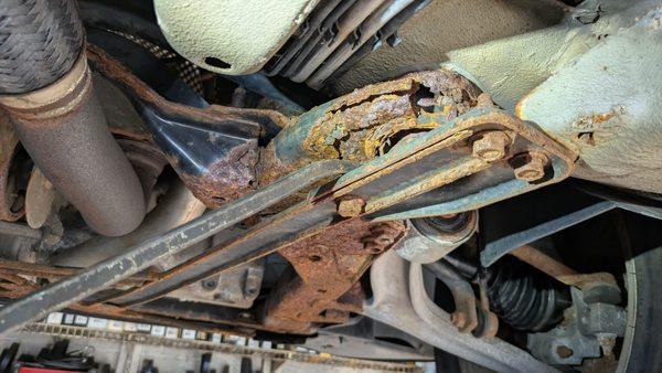 Totally rusted subframe, but notice the new right front axle though (sigh). Waiting for the subframe to come in for the pricey repair.