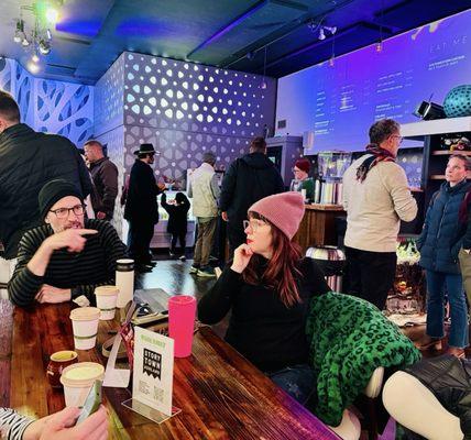 Inside White Rabbit, sitting at a table near the bar where they serve alcoholic and non-alcoholic drinks and creative snacks.