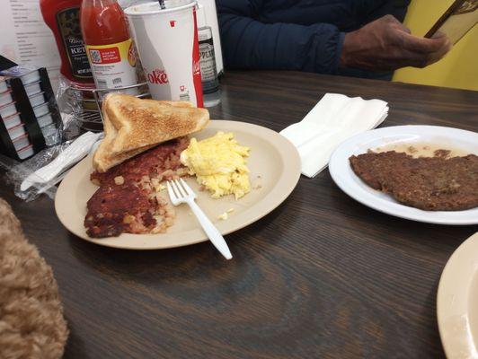 Two eggs and bacon with hash brown and toast