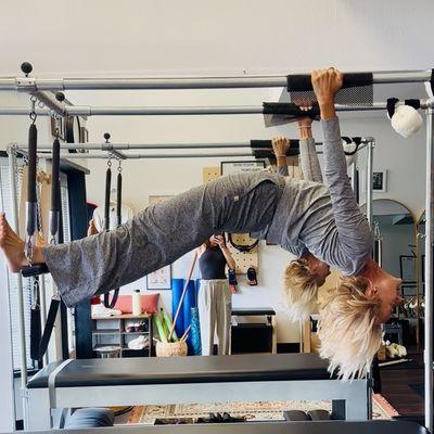 Spinal extension shown with Hanging Pull Ups on the Cadillac. Your body needs movement and strength without damage to your joints.